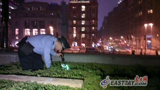 由于怀疑凶器被扔到草丛中，警方在夜幕下打着手电仔细地察看每一处可疑的地方。